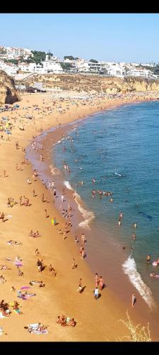 a large group of people on a beach at AlbufeiraSun, arrive as a guest leave as a friend. in Albufeira