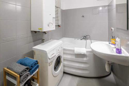 uma casa de banho branca com uma máquina de lavar roupa e um lavatório em Justi Old Town Apartment Studencka em Cracóvia