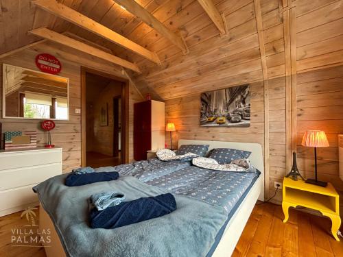 MatyldówにあるVilla Las Palmasの木製の部屋に大型ベッドが備わるベッドルーム1室が備わります。