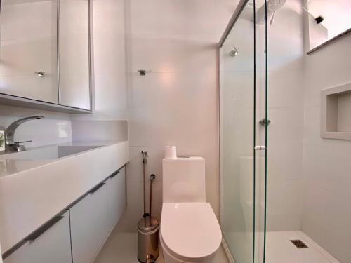 a bathroom with a toilet and a glass shower at Residencial Maranello in Ilhéus