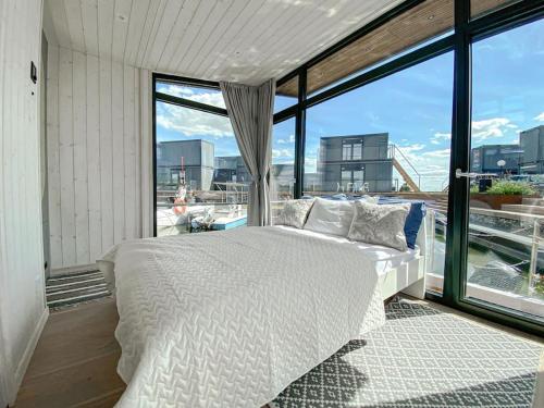 a bedroom with a white bed and a large window at Twin Boats - Butterfly in Dreverna