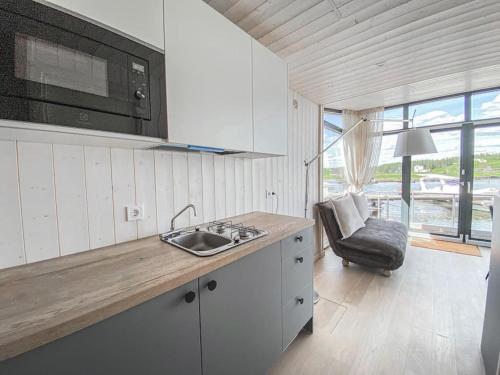 a white kitchen with a sink and a microwave at Twin Boats - Butterfly in Dreverna