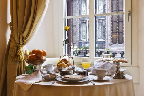una mesa con un plato de comida y una ventana en Granduomo Charming Accomodation, en Florencia