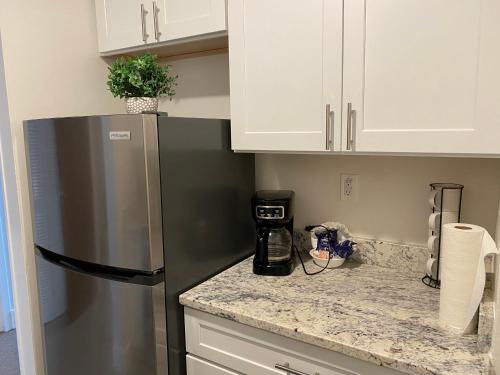 a kitchen with a stainless steel refrigerator and white cabinets at Quaint studio apartment in Gadsden, Al in Gadsden