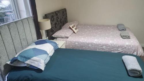 a small bedroom with two beds and a window at Ballentree Stay in Dublin