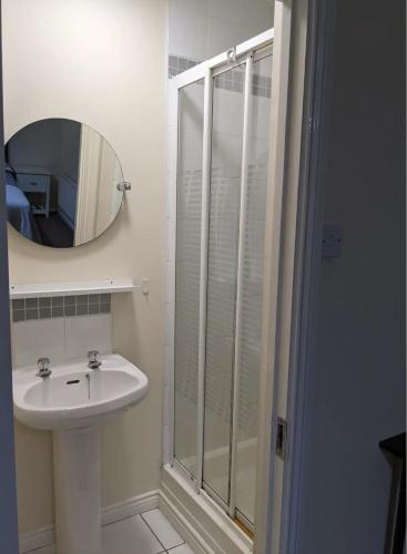 a bathroom with a sink and a shower with a mirror at Ballentree Stay in Dublin
