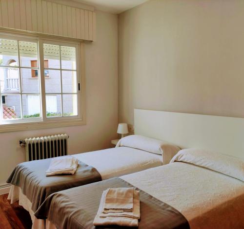 um quarto com 2 camas e uma janela em Apartamentos Sanxenxo Progreso 140 em Sanxenxo