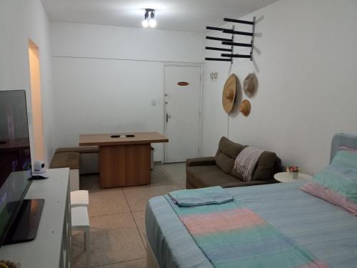 een woonkamer met een bed en een bank bij Apto frente ao mar, ar cond. frio e Wi-Fi in São Vicente