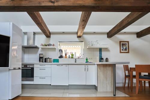 a kitchen with white cabinets and a table at Urlauberei Malchow in Malchow