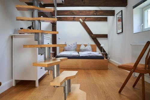 a room with a bed and a loft with wooden stairs at Urlauberei Malchow in Malchow