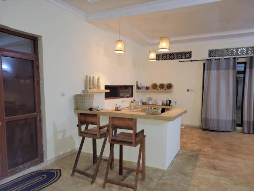 een keuken met een tafel en stoelen in een kamer bij Villa Pumziko in Kizimkazi