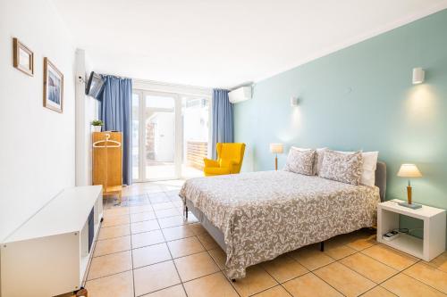 a bedroom with a bed and a tv in it at Stunning terrace with ocean view in Albufeira