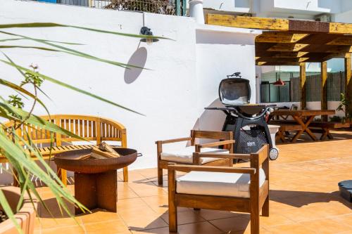 a patio with chairs and a scooter on it at Stunning terrace with ocean view in Albufeira