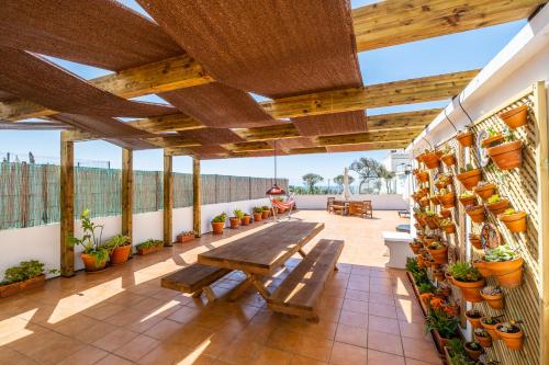 a patio with a wooden bench and potted plants at Stunning terrace with ocean view in Albufeira