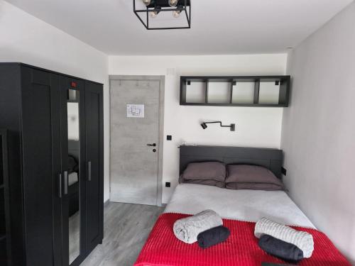 a bedroom with a bed with a red blanket at Apartment ILLARIA in Rijeka