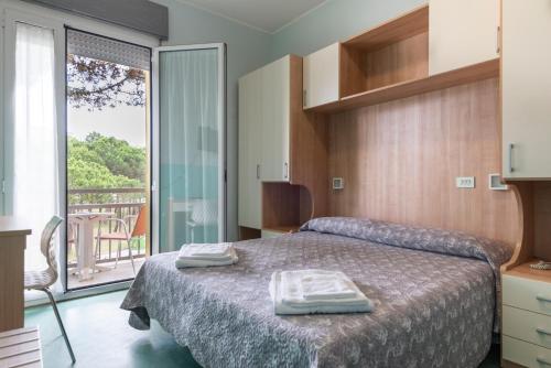 a bedroom with a bed with two towels on it at Hotel Olympic in Milano Marittima