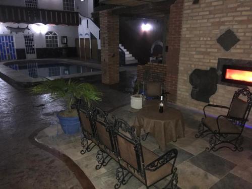 a room with a table and chairs and a pool at HOTEL Y VILLAS CASA AZUL in Rincon de Guayabitos