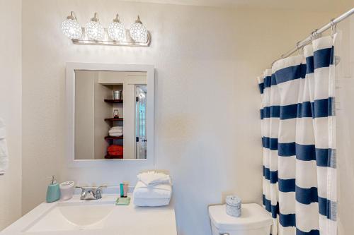 ein Badezimmer mit einem Waschbecken, einem Spiegel und einem WC in der Unterkunft Grand Caribbean East & West, E212 in Perdido Key