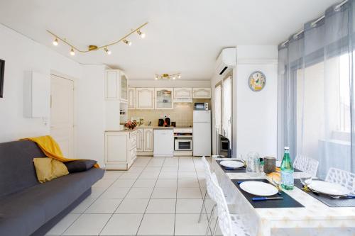 une cuisine et un salon avec un canapé et une table dans l'établissement Magnolia YourHostHelper, à Sainte-Maxime