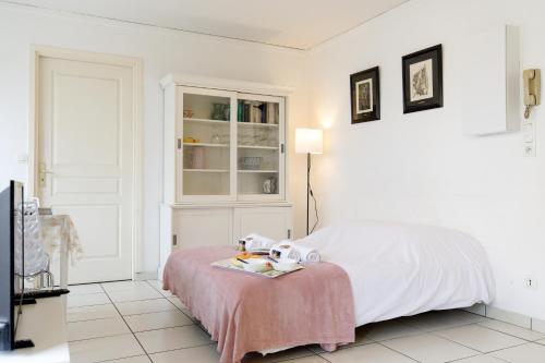 une chambre blanche avec un lit et une table dans l'établissement Magnolia YourHostHelper, à Sainte-Maxime