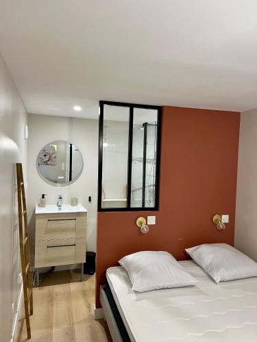 une chambre avec un lit, un lavabo et un miroir dans l'établissement CASA Salta, à Cholet