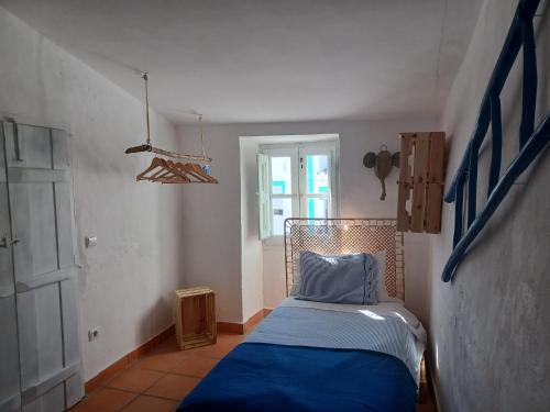 - une chambre avec un lit doté de draps bleus et une fenêtre dans l'établissement Villa Oliva São Pedro, à São Pedro do Corval