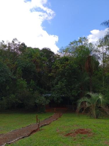 a yard with a fence and grass and trees at Yurtas Ivirareta Glamping in Garupá