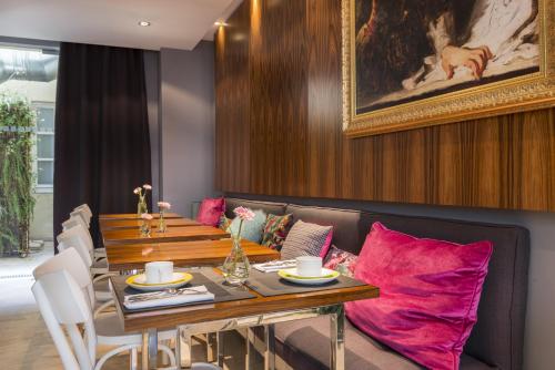 une salle à manger avec une table et des oreillers roses dans l'établissement Hotel Le Placide Saint-Germain Des Prés, à Paris