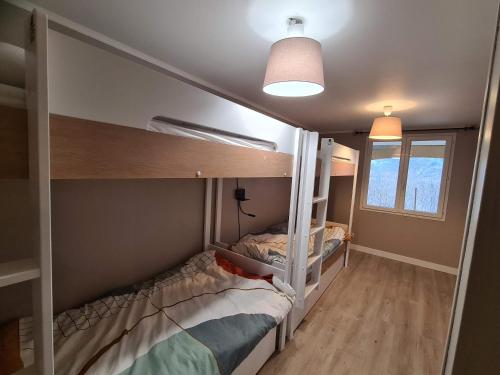 a bedroom with two bunk beds and a window at Les Balcons de l'Eterlou in Les Deux Alpes