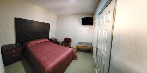 - une chambre avec un lit doté d'un couvre-lit rouge dans l'établissement Casa DOTO, à Ciudad Sahagún