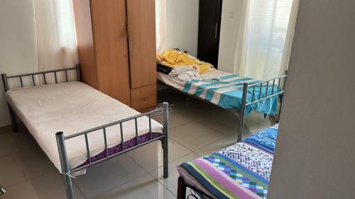 um pequeno quarto com 2 camas e um espelho em JP Apartment em Dubai