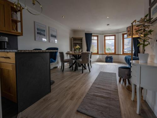 a kitchen and living room with a table and chairs at Canalside Apartment in Fort William
