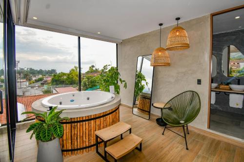 uma casa de banho com uma banheira, uma mesa e uma cadeira em Hotel Salento Real Eje Cafetero em Salento