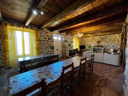 une grande salle à manger avec une table et des chaises dans l'établissement Gite à la ferme au coeur de l'Auvergne, à Saint-Hippolyte