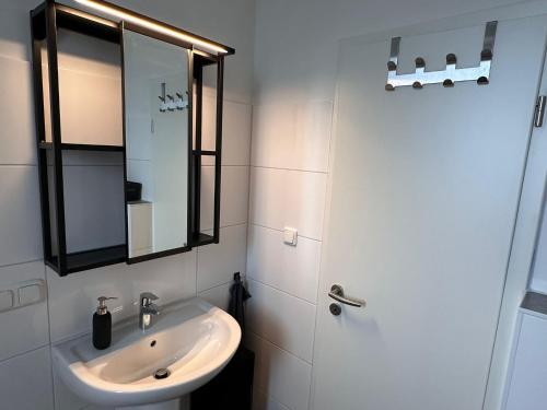 a white bathroom with a sink and a mirror at Dream Living 1 im Essener Süden in Essen