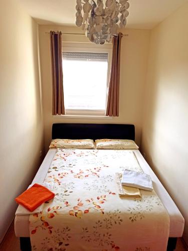 a small bedroom with a bed with a window at Nagyerdő - Simonyi út in Debrecen