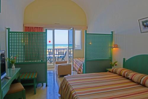 a bedroom with a bed and a view of the ocean at Hotel Meninx Djerba in Triffa