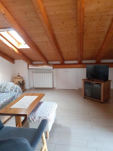 Una sala de estar con una mesa y un televisor. en La terrazza, en Ragalna