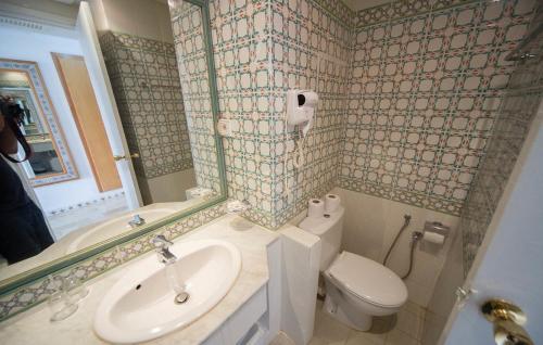 ein Bad mit einem Waschbecken und einem WC in der Unterkunft Hotel Meninx Djerba in Triffa