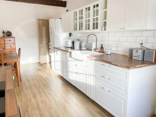 a kitchen with white cabinets and a wooden floor at Chalupa Rozálka in Cerny Dul