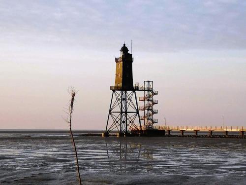 a lighthouse on a pier in the water at Charmantes Ferienhaus mit Kamin in Lintig in Lintig