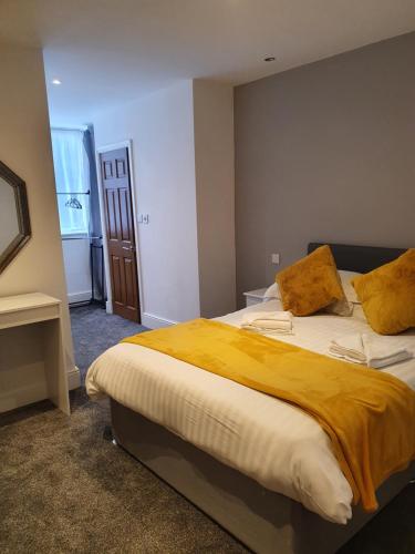 1 dormitorio con 1 cama grande con manta amarilla en Imperial view, en Blackpool
