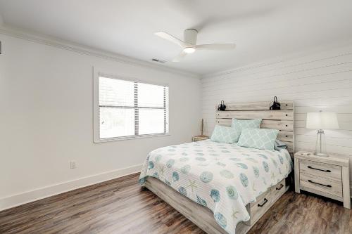 a white bedroom with a bed and a window at C Turtle in Edisto Island
