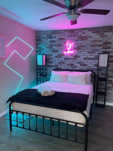 a bedroom with a bed with a neon sign on a brick wall at Apartment near TPA Airport in Tampa