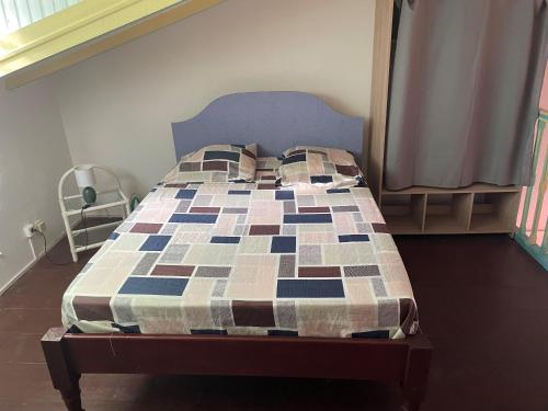 a bed with a quilt on it in a bedroom at Residence Chez Marraine BERTILI in Le Gosier