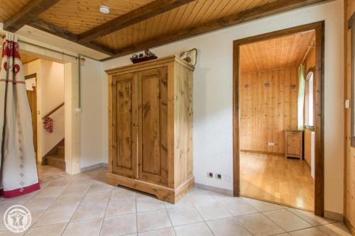 a room with a wooden cabinet and a hallway at Chalet la griotte in Abondance