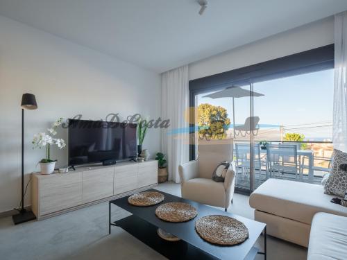 uma sala de estar com uma televisão e um sofá em CASCADA del MAR II - GRAN ALACANT em Gran Alacant
