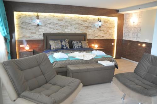 a bedroom with a bed and two chairs at Hotel Goreme Sakura in Pamukkale