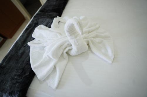 バンガロールにあるCastle Suites by Haven Homes, Kempegowda International Airport roadのベッドの上に置かれた白いタオルの山