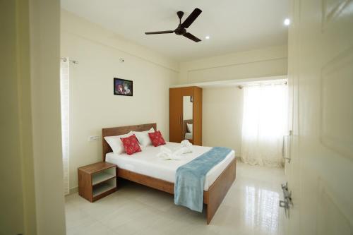a bedroom with a bed with a ceiling fan at Castle Suites by Haven Homes, Kempegowda International Airport road in Bangalore